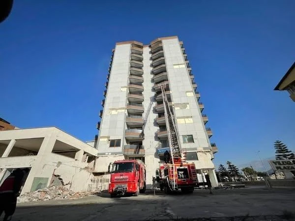 İskenderun'da deprem hasarları nedeniyle yıkılan bir binanın en üst katında çıkan yangın-1