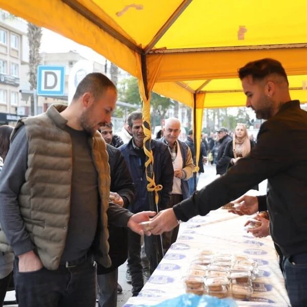 Didim Merkez Camii önünde kurulan stantta vatandaşlar kandil simidi yiyor.-4