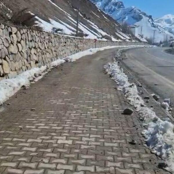 Yürüyen bir kişi taş düşmelerinden dolayı dikkatli bir şekilde yol alıyor